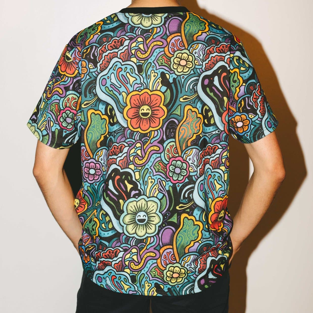 The back of a man wearing the Nomu shirt, a dense all over floral print in many colours